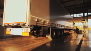 Red truck with cargo trailer pulls into a service station for annual service.