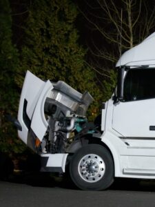 Semi truck with open hood and engine repairs