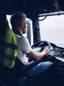 Handsome driver at the wheel of a truck at work.